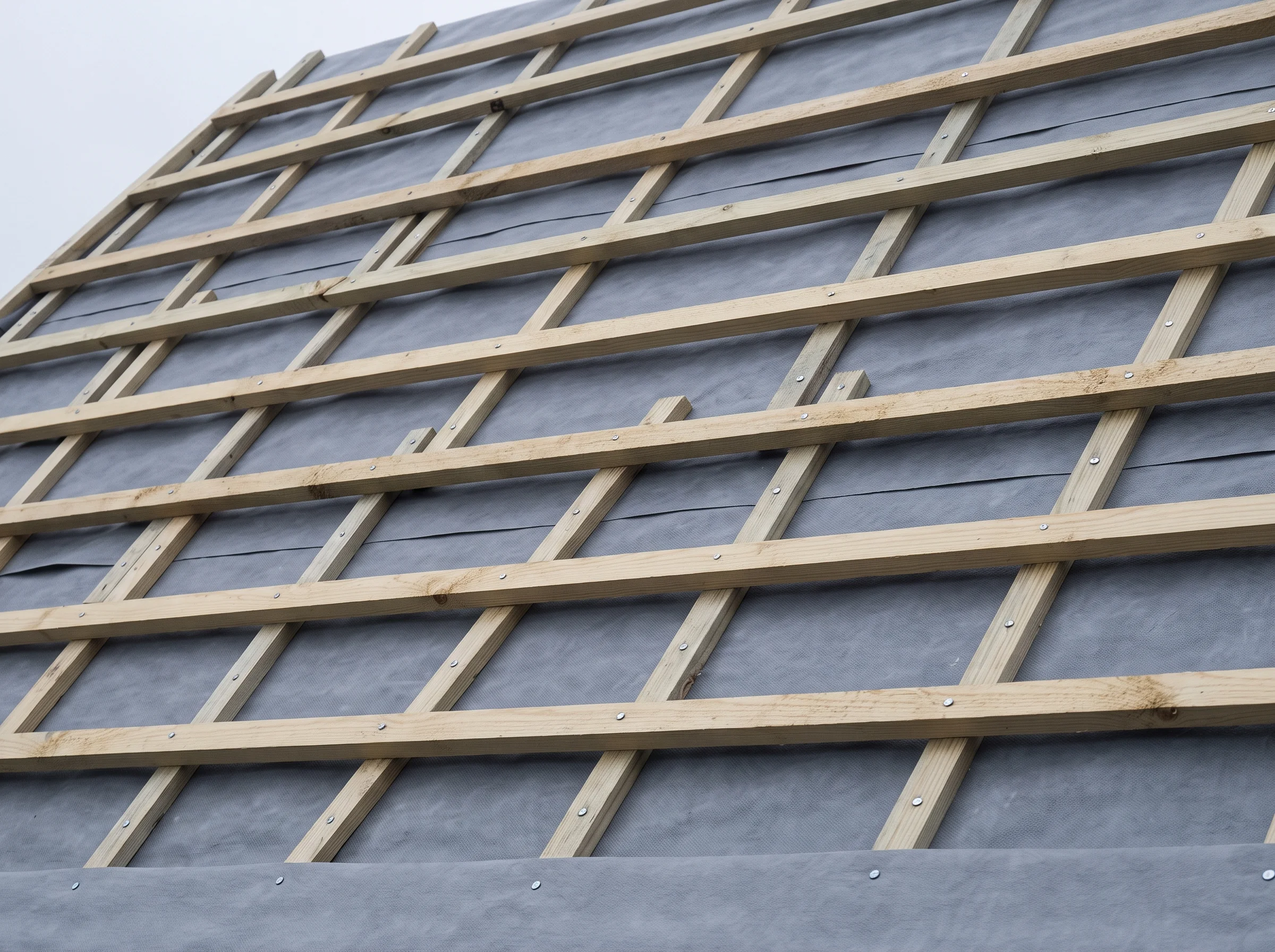 Fresh battens set to gauge across membrane on a long school roof slope